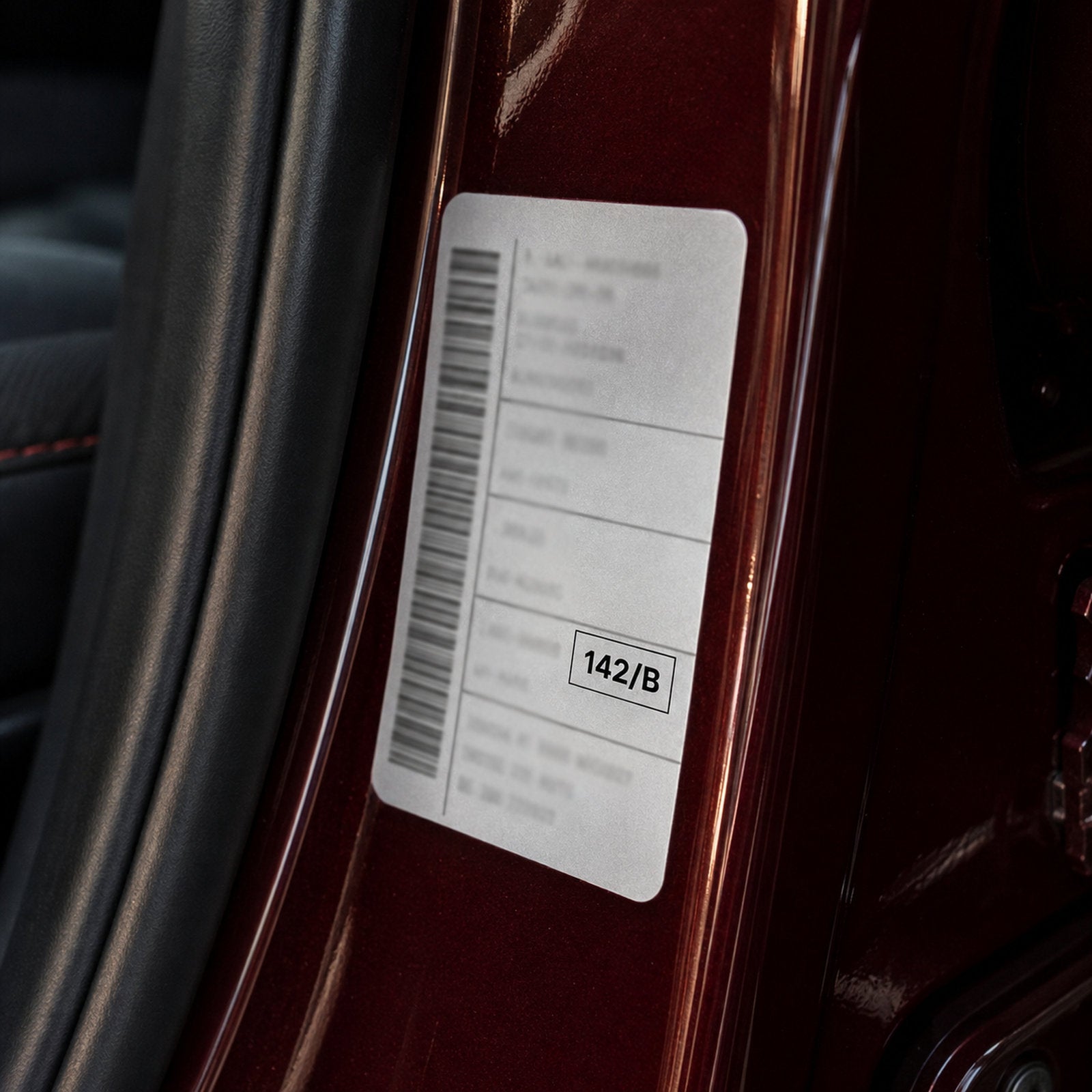 Car paint code sticker (142/B) in the driver's door jamb of a black car